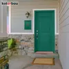 A green mailbox mounted on a stone-clad wall next to a front door. Anteprima dell’immagine prodotto
