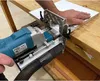 A person is using a dowel drilling machine to work on a piece of wood. Produktbild-Vorschau