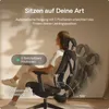A woman is sitting in an ergonomic office chair, demonstrating its reclining features. Podgląd zdjęcia produktu