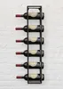 A black metal wine rack mounted on a white brick wall, holding six bottles of red wine. Náhled obrázku produktu