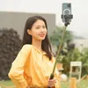 A young woman is taking a selfie outdoors with a selfie stick. Voir les images du produit