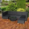 A black rattan lounge set with a glass-topped coffee table is placed on a wooden deck in a garden setting. Anteprima dell’immagine prodotto