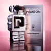 A silver robot-shaped perfume bottle and its packaging are displayed against a pink background. Voir les images du produit