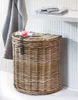 A wicker laundry basket with a lid and a leather strap is shown in a bathroom setting. Podgląd zdjęcia produktu