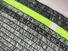 A close-up of a dark green shade net with a neon green stripe. Produktbild-Vorschau