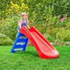 A young child is playing on a red and blue slide in a garden. Anteprima dell’immagine prodotto