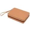 A tan colored zippered case with a wrist strap, shown from a diagonal angle on a white background. Podgląd zdjęcia produktu