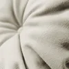 A close-up view of the textured fabric of a cushion or cushion cover, showing the weave and a tufted detail. Produktbild-Vorschau