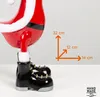 A close-up of a Santa Claus figurine's lower body and boots, with a size chart overlay indicating dimensions. Produktbild-Vorschau