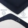 Close-up of a dark blue fitted sheet showing its elastic edge and marketing callouts. Anteprima dell’immagine prodotto