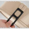 A hand holding a black tool over a beige baking pan. Produktbild-Vorschau