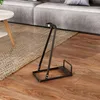 A black vacuum stand is placed on a wooden floor next to a rug and a sofa. Produktbild-Vorschau
