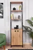 A tall, narrow bookshelf with wooden shelves and a cabinet at the bottom, placed in a room with a green armchair and a plant. Produktbild-Vorschau