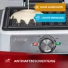 Close-up of a waffle maker with batter being poured onto the plates, showing control knobs and indicator lights. Produktbild-Vorschau