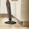 A steam mop is cleaning a tiled floor next to kitchen cabinets. Produktbild-Vorschau