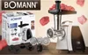 A Bomann meat grinder is shown with its packaging and accessories, along with pieces of raw meat flying around it. Náhľad obrázku produktu