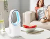 A woman is eating watermelon on a couch while a white fan sits on a coffee table. Produktbild-Vorschau