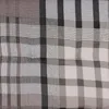 A close-up view of a fabric with a plaid pattern in various shades of brown, gray, and white. Produktbild-Vorschau