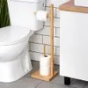 A toilet paper holder next to a toilet in a bathroom. Náhled obrázku produktu