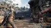 Kratos stands on a wooden pier overlooking a bustling marketplace with a large statue in the background. Náhľad obrázku produktu
