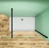 Top-down view of a shower enclosure with a white shower tray, glass panels, and black metal supports, set against a light green wall and a wooden floor. Produktbild-Vorschau