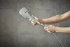 A person's hands holding a shower head. Anteprima dell’immagine prodotto