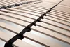 Close-up view of wooden bed slats with black straps. Produktbild-Vorschau