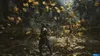 A person in a dark outfit swings a sword in a forest clearing, with leaves swirling around them. Produktbild-Vorschau