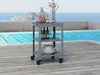 A dark gray serving cart is placed on a wooden deck next to a swimming pool with a view of the ocean and islands in the background. Anteprima dell’immagine prodotto