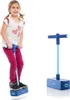 A young girl is jumping on a pogo stick, with another pogo stick shown to the right. Produktbild-Vorschau