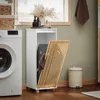 A laundry room scene with a washing machine, a white cabinet with a slatted door, a laundry basket inside, and a trash can. Anteprima dell’immagine prodotto