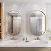 A modern bathroom vanity with two oval mirrors, sinks, and faucets. Voir les images du produit