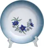 A decorative plate with a floral pattern is displayed on a clear stand. Produktbild-Vorschau