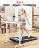 A woman is walking on a treadmill under a standing desk in a well-lit room. Produktbild-Vorschau