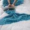 Taubengrüne gestrickte Meerjungfrau-Schwanzdecke, getragen von einer Person, die auf weißer Bettwäsche einen Laptop benutzt Anteprima dell’immagine prodotto