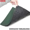 A hand holding up a sample of a green and black layered product, likely a mat or flooring. Produktbild-Vorschau