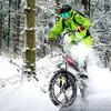 A person riding a fat-tire electric bicycle through a snowy forest. Produktbild-Vorschau