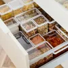 An open drawer filled with various food items stored in clear plastic containers. Produktbild-Vorschau