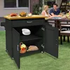 A couple is dining at a table outdoors, with a kitchen cart nearby. Voir les images du produit