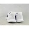The back view of a pair of white Adidas running shoes against a light gray concrete background. Produktbild-Vorschau