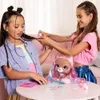 Two young girls are playing with a styling head doll on a pink table. Podgląd zdjęcia produktu