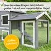 A wooden rabbit hutch with multiple levels and an attached outdoor run, set in a grassy outdoor environment. Produktbild-Vorschau