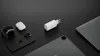 A collection of Apple electronic devices and a white charging adapter are arranged on a black surface. Náhled obrázku produktu