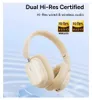 A pair of beige wireless headphones is shown against a light blue and white background with wavy patterns. Anteprima dell’immagine prodotto