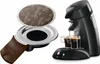A coffee machine with two cups of coffee being brewed, and a coffee pod and holder shown separately. Náhľad obrázku produktu
