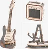 A collage of a wooden model electric guitar, a wooden model amplifier, and a wooden model guitar stand. Voir les images du produit