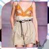 A model wearing a fashion outfit, focusing on the belt and shorts. Náhled obrázku produktu