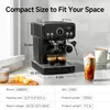 A black espresso machine is shown on a kitchen counter with two shots of espresso, an iced coffee, and a mug of coffee. Produktbild-Vorschau
