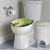 A toilet with a decorative seat cover featuring a bamboo and stone design, shown in a bathroom setting with a toilet paper holder and a trash can. Produktbild-Vorschau