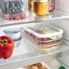 A close-up view of a refrigerator shelf containing various food items and storage containers. Produktbild-Vorschau